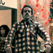 Zombie z ciemnymi kręconymi włosami i w koszuli w kratę
